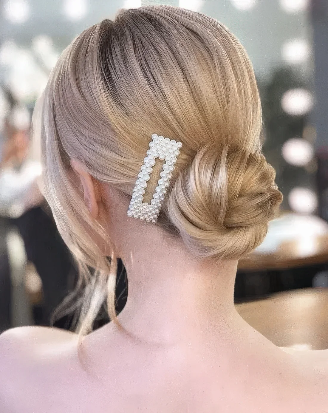 Twisted low bun accented with a pearl hair clip.