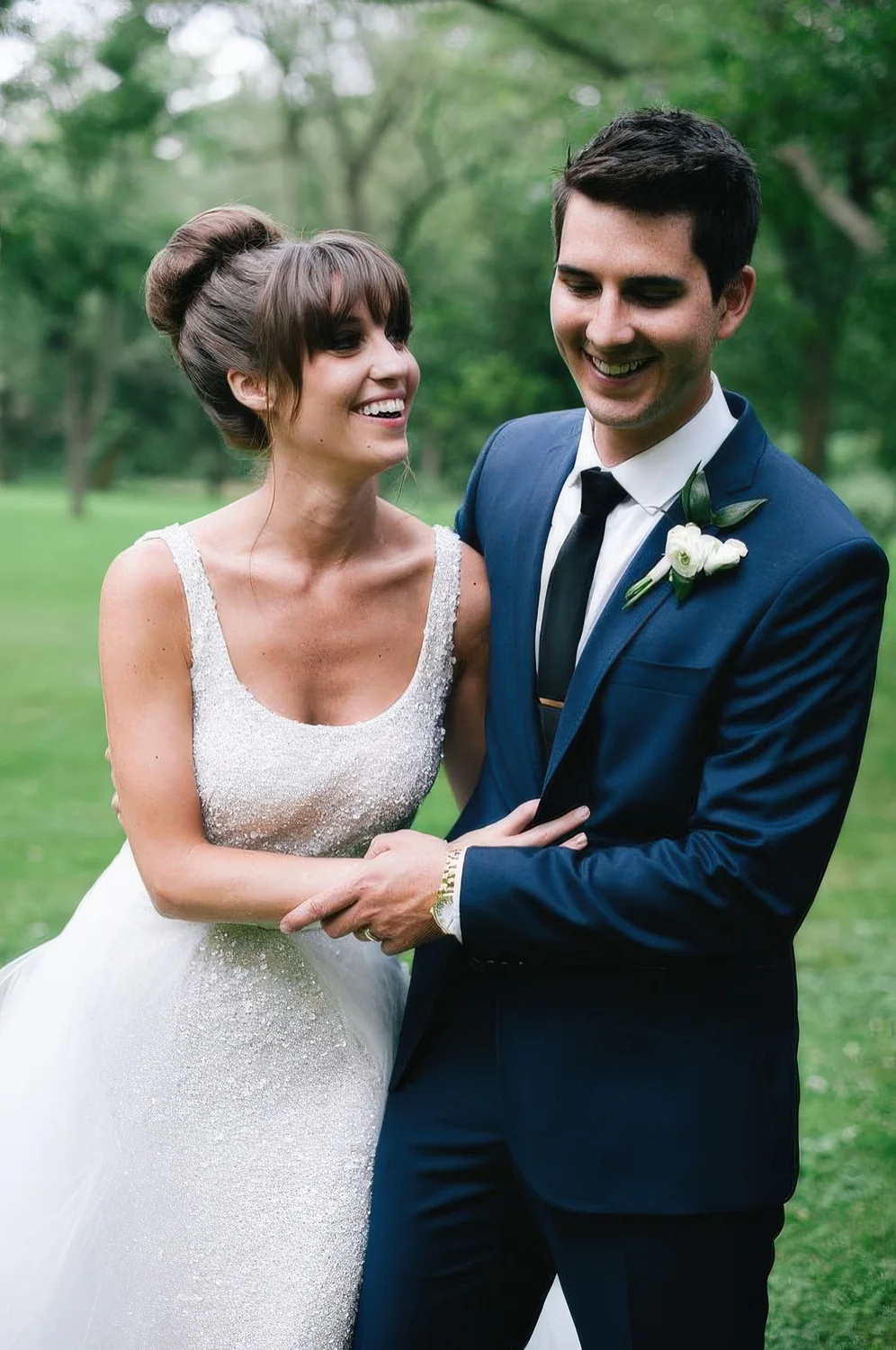 Top knot, much volume and bangs for an elegant and chic bridal look with a fully embellished dress.