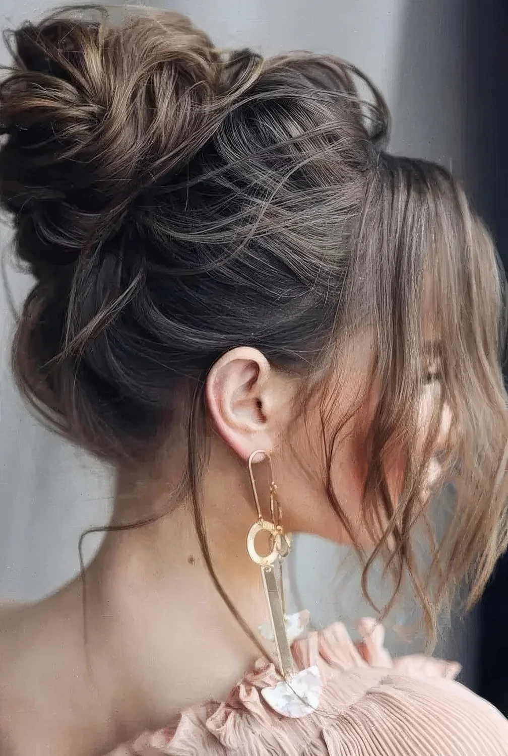 Messy and volumetric top knot with face-framing locks.