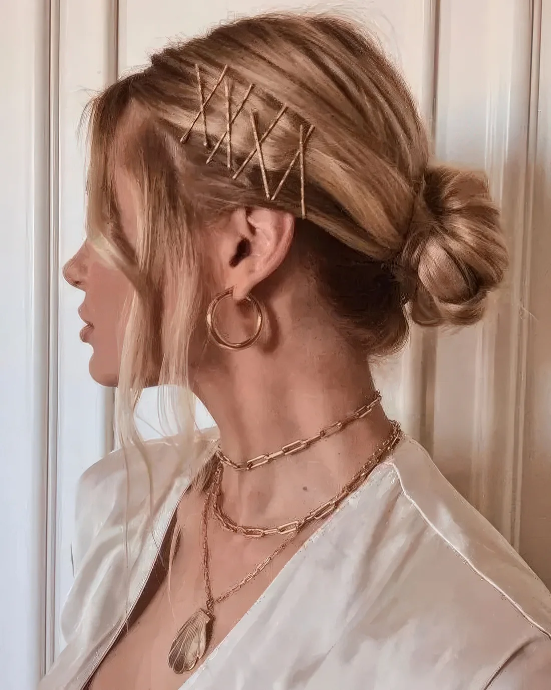 Low bun with a volume on top and face-framing hair plus bobby pins on one side.