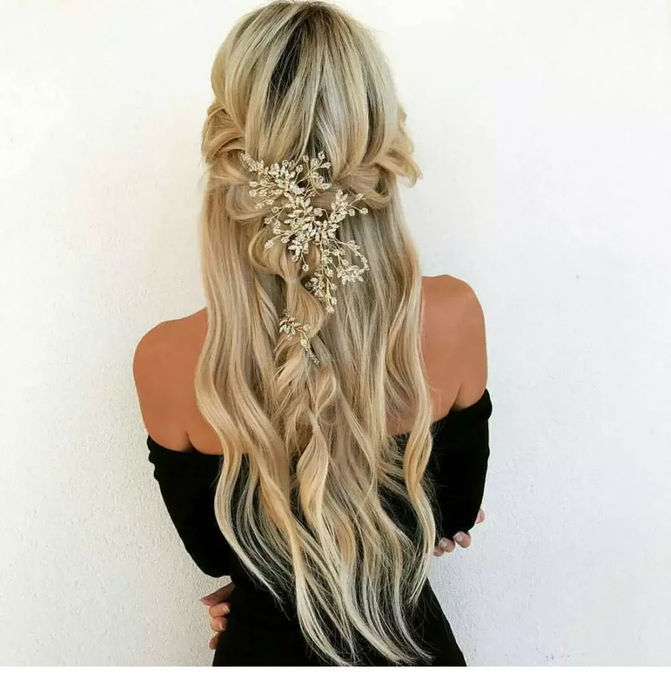 chest wavy brunette ponytail shown as a wedding hairstyles ideas for long hair idea, featuring wavy texture, shown in extra long blonde half up wedding hair