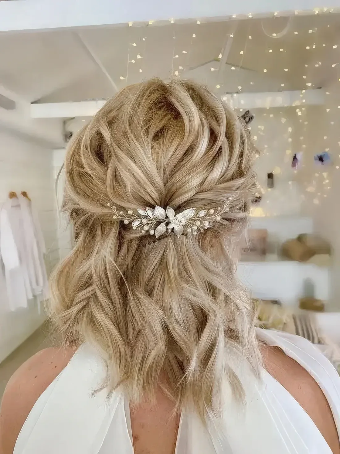Easy half updo with wavy hair and an embellished hair piece.