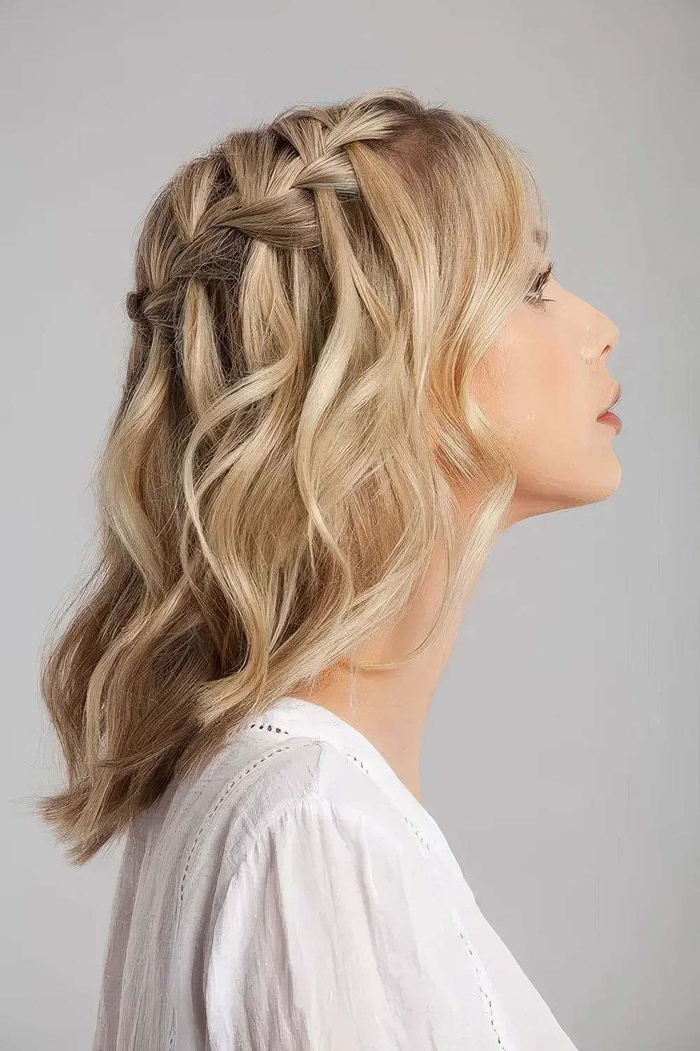Blonde medium-length half updo with a braided top and waves down.