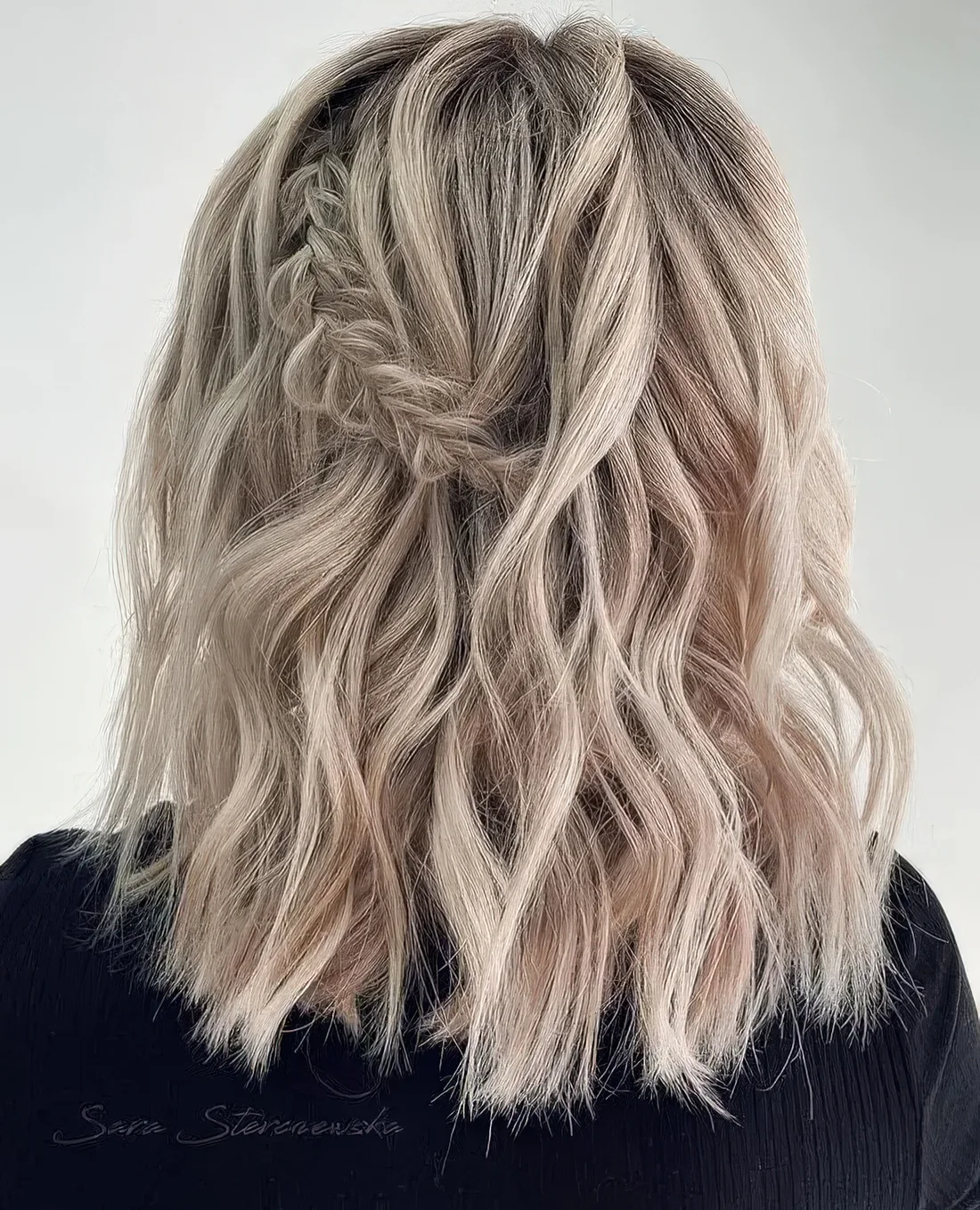 Boho half updo with a waves, a braided element and a lot of volume.