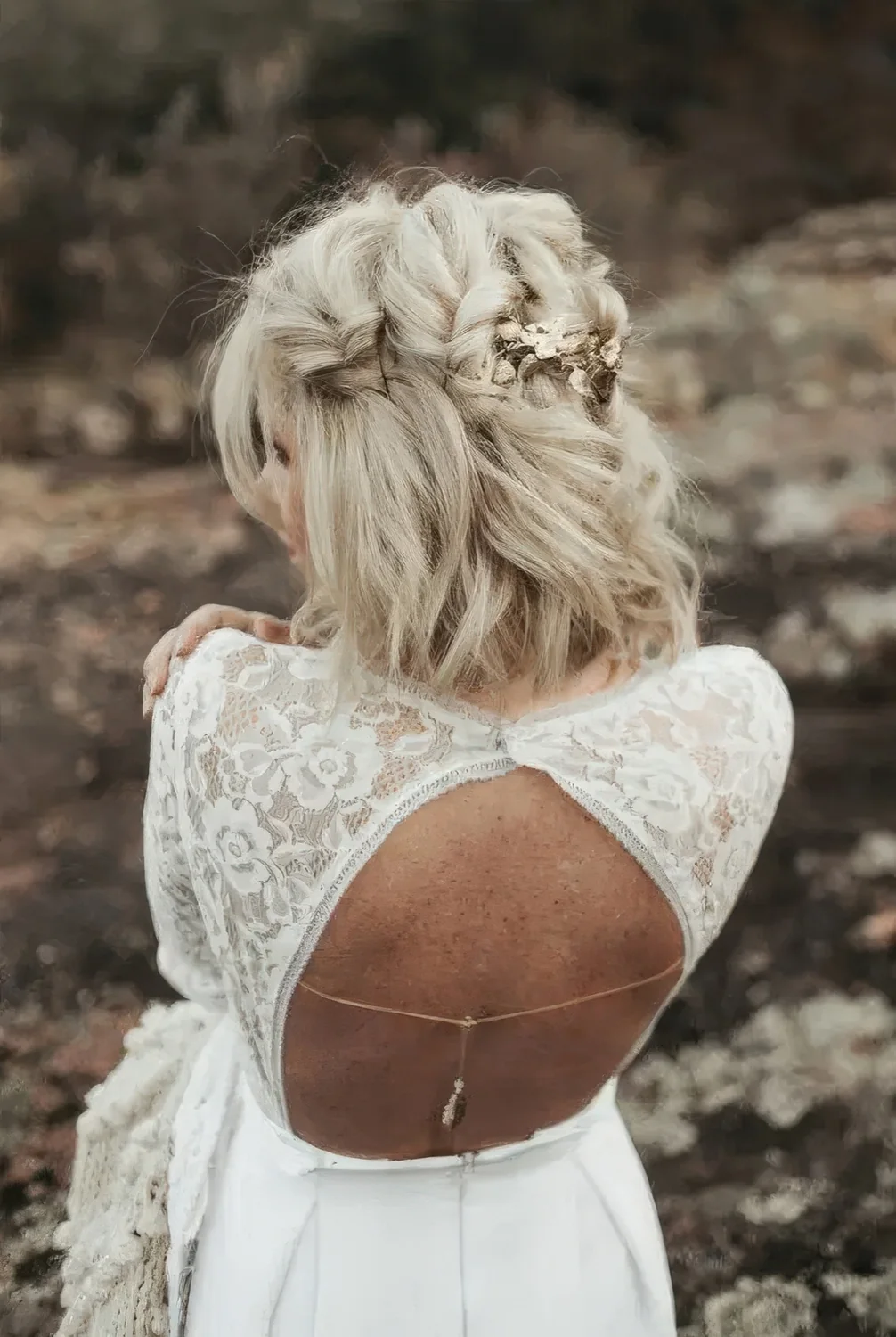 Blonde medium half updo with large twisted braids and gold floral hairpins.