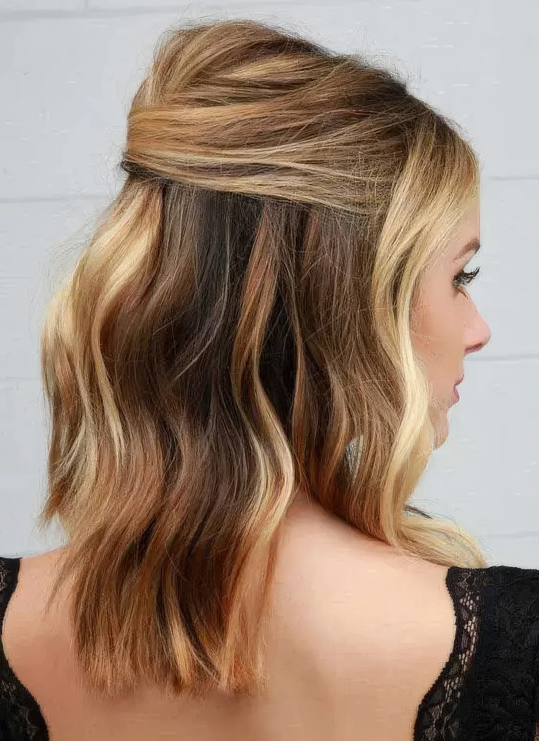 Chic and sexy half updo with a bump on top and wavy hair down.