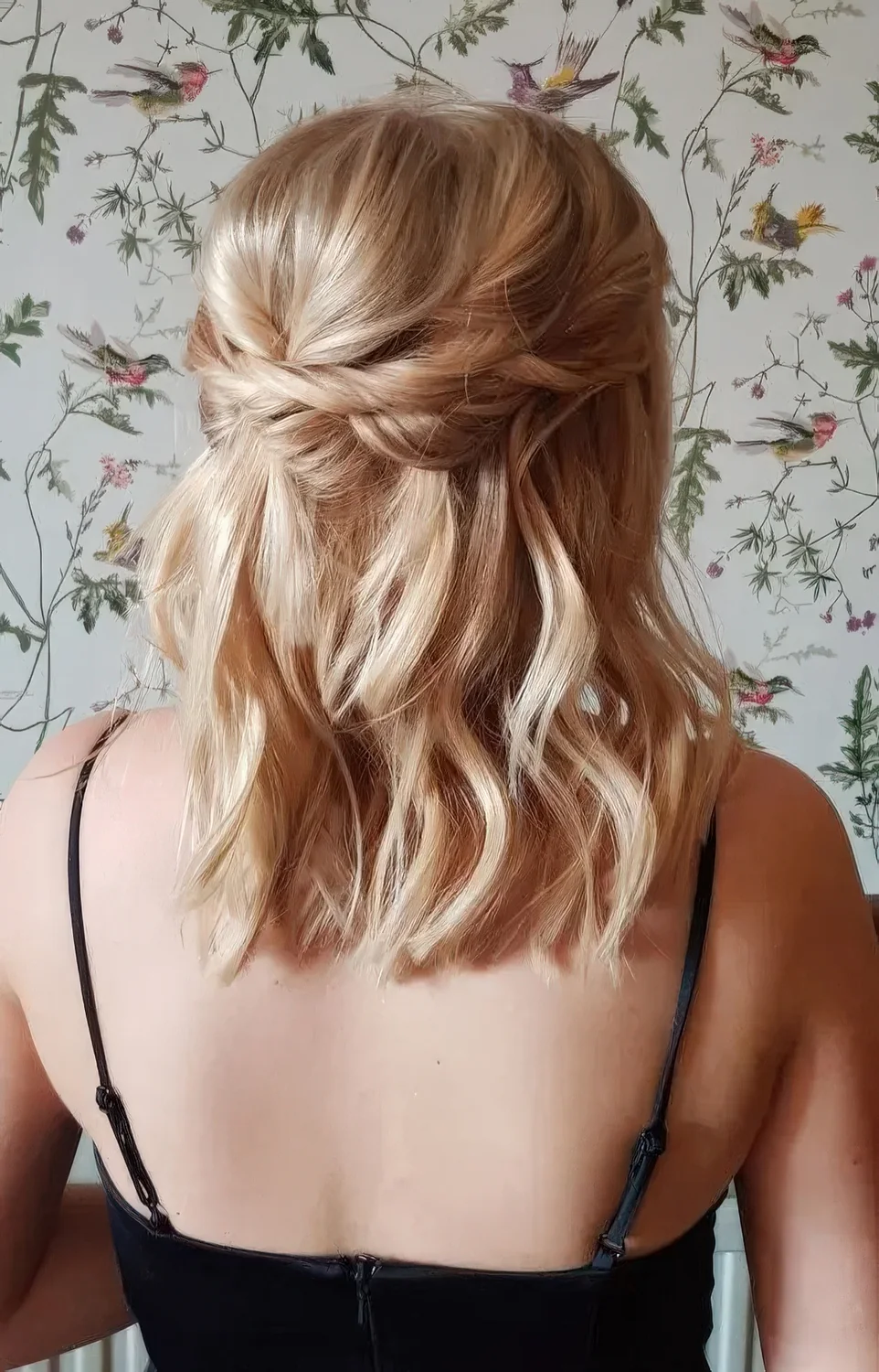 Relaxed blonde medium half updo with a bump on top, twists and waves down.