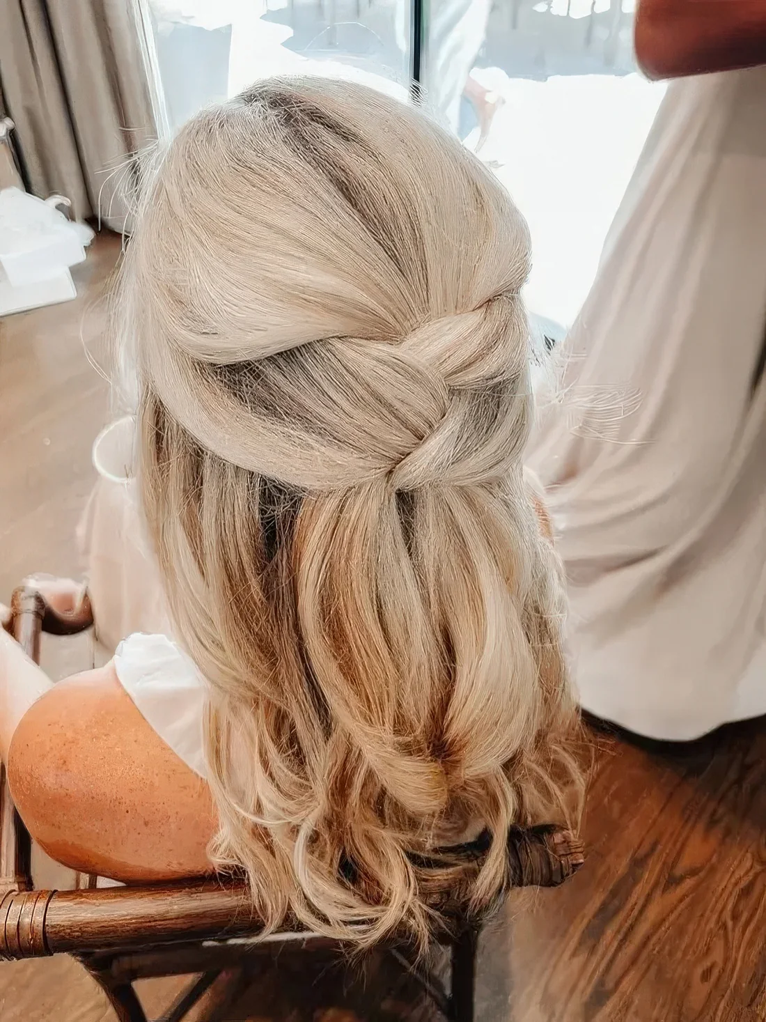 Blonde half updo with a couple of twists and wavy ends.