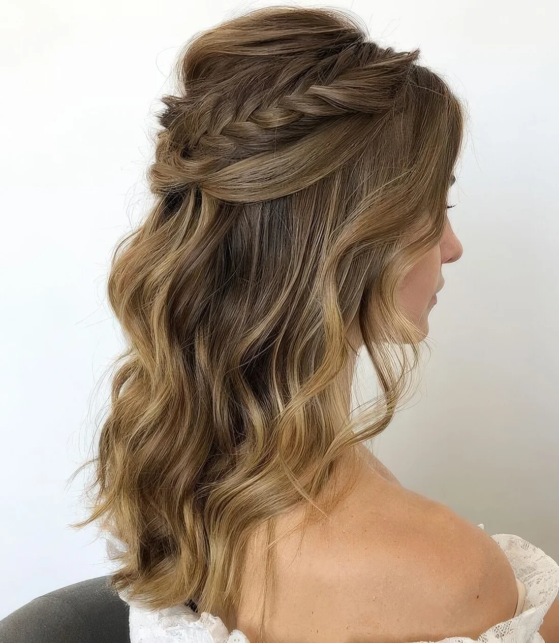 Wedding half updo with a bump on top and a braided and twisted halo plus waves down.