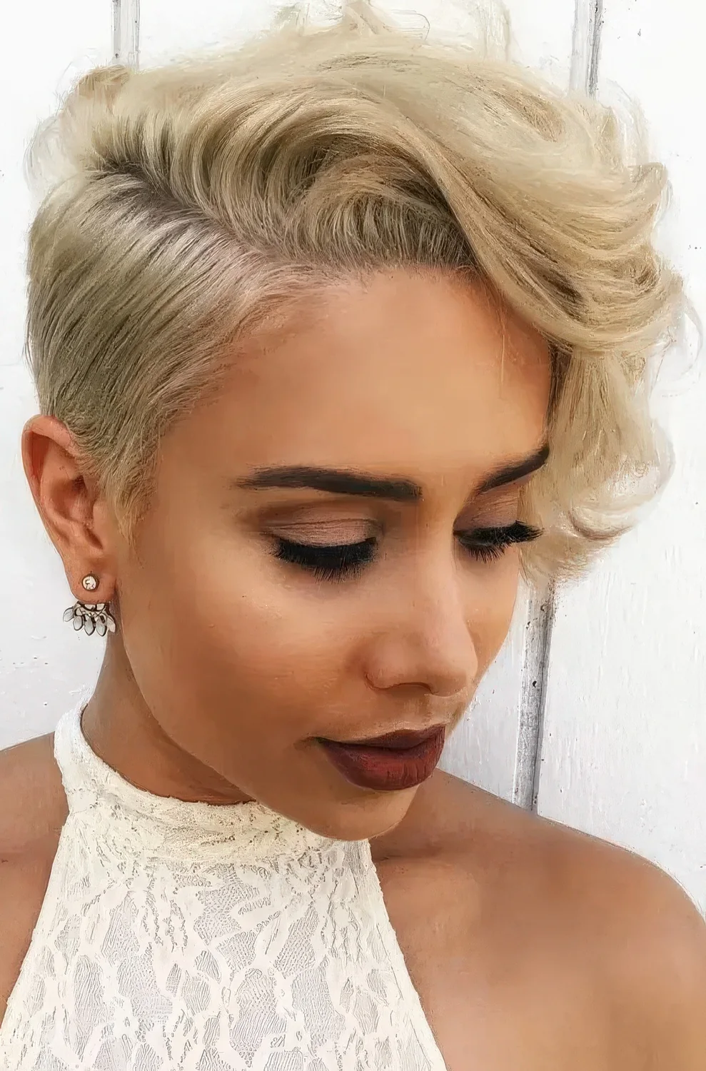 Creamy blonde long wavy pixie with side part.
