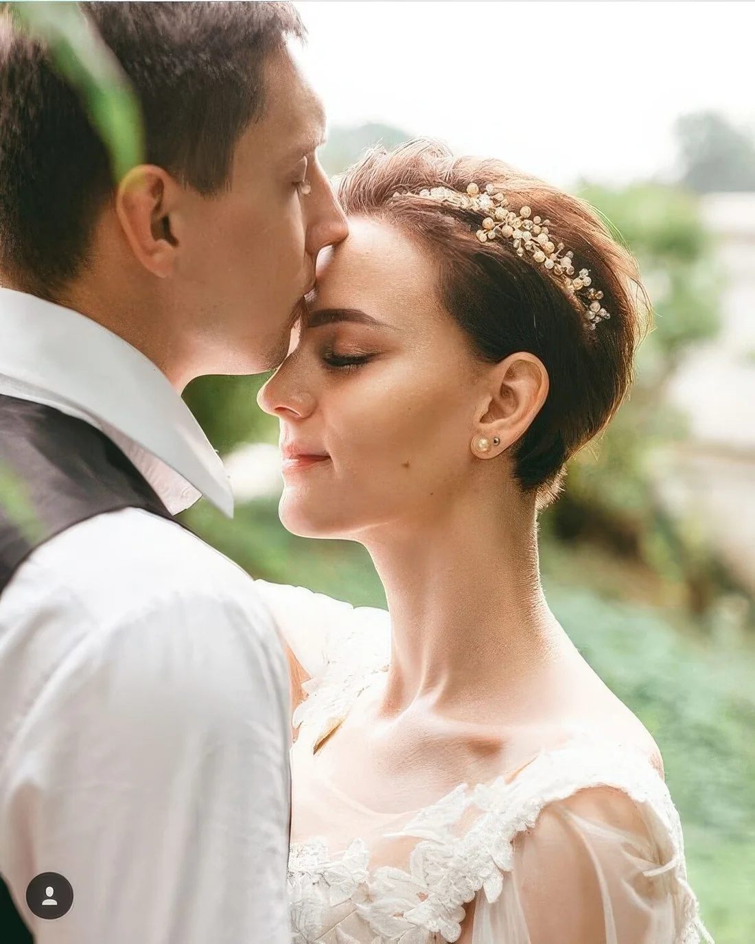 Dark brunette pixie cut with a pearl hair piece.