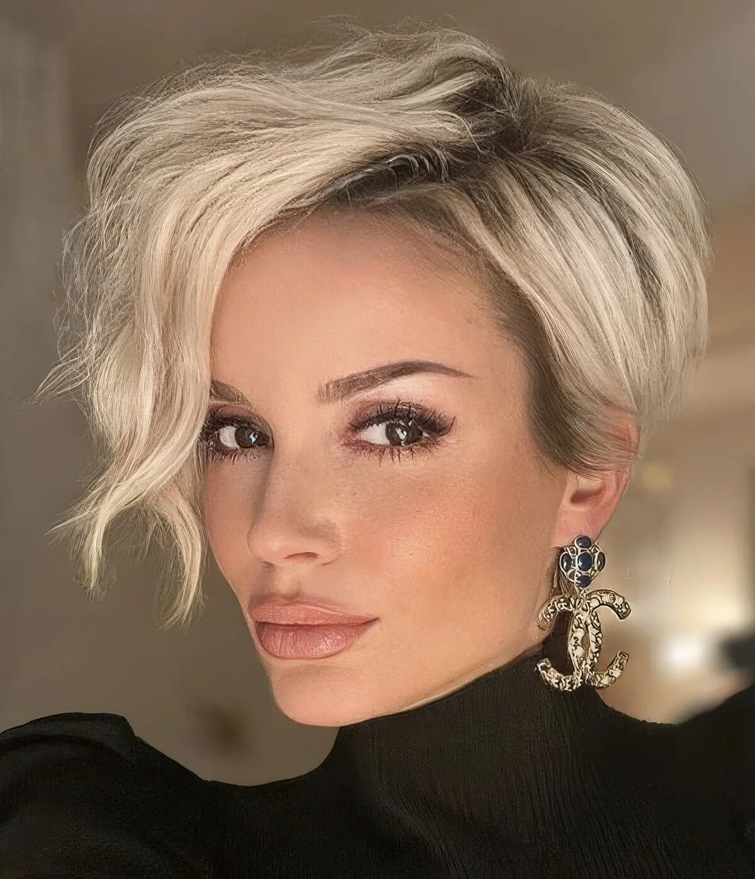 Long blonde pixie cut with a lot of volume and waves.