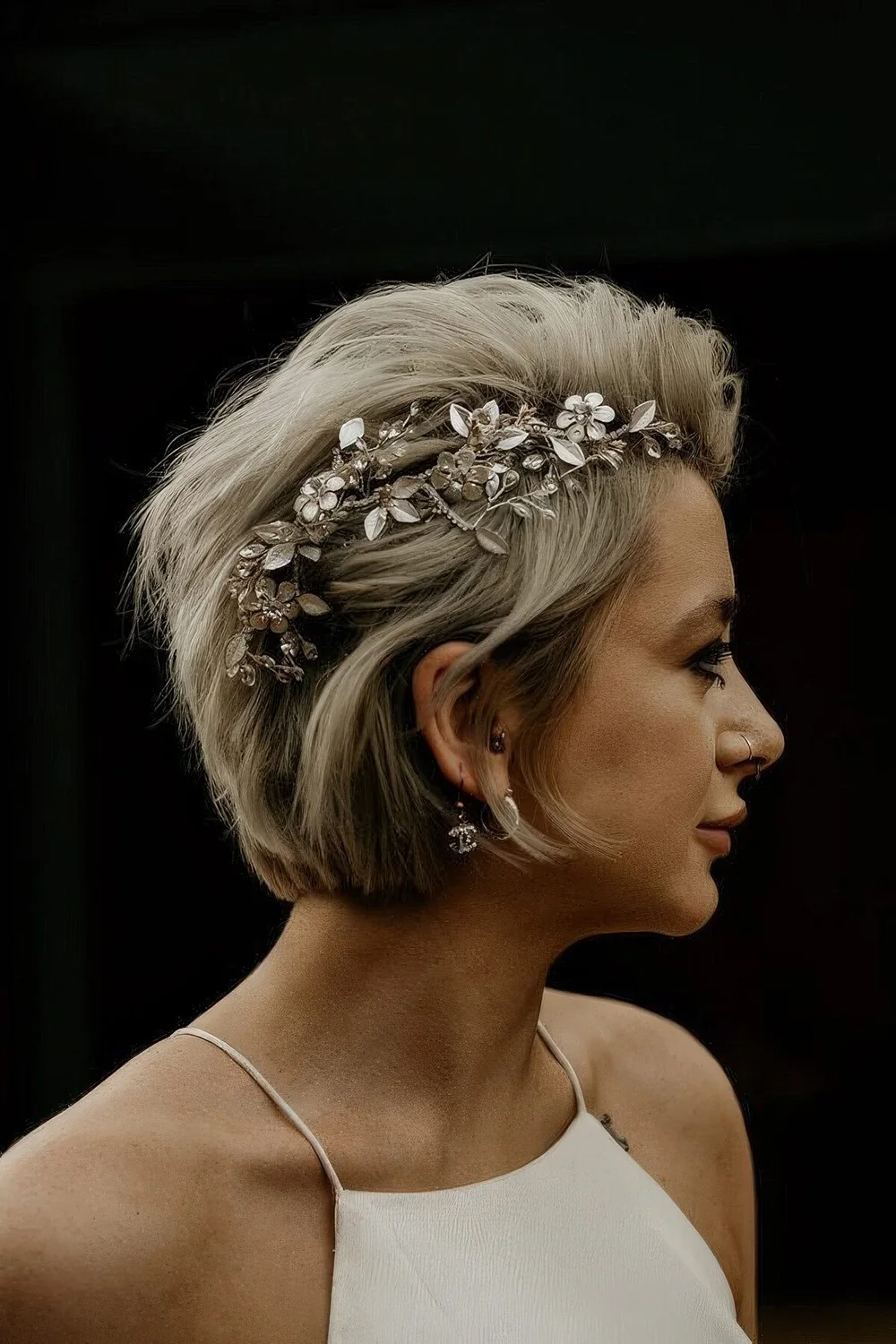 Long blonde pixie to bob haircut accented wih a gorgeous floral hair piece.