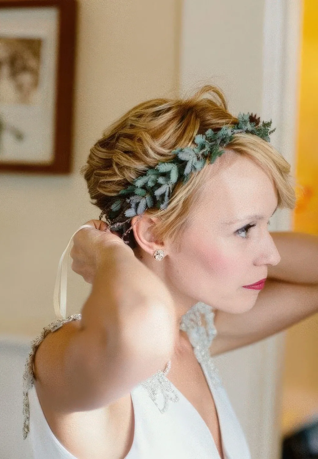 Long honey blonde pixie cut with waves and a greenery crown.