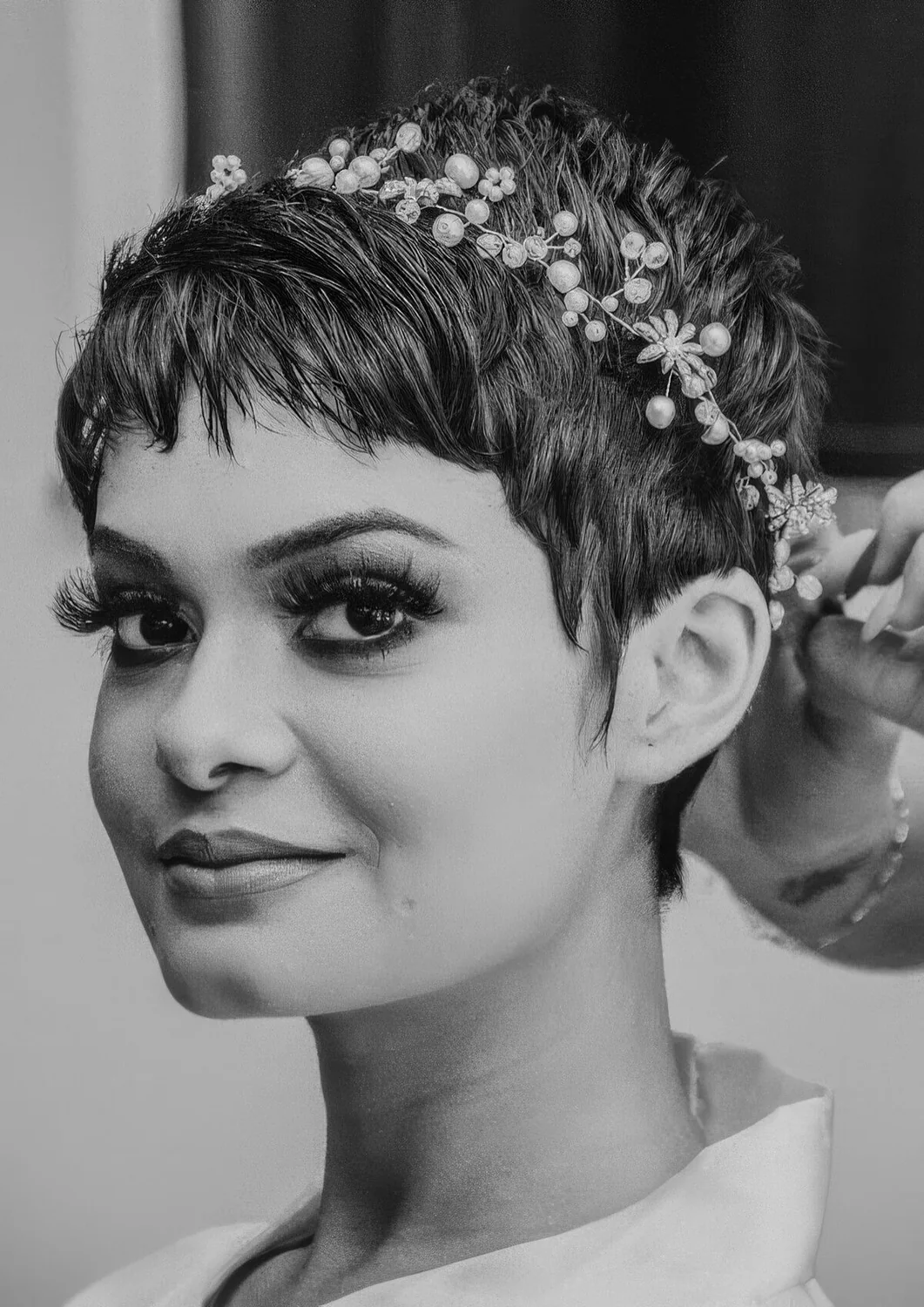 Long pixie haircut with a bit of messy volume and a pearl and rhinestone hiar vine.