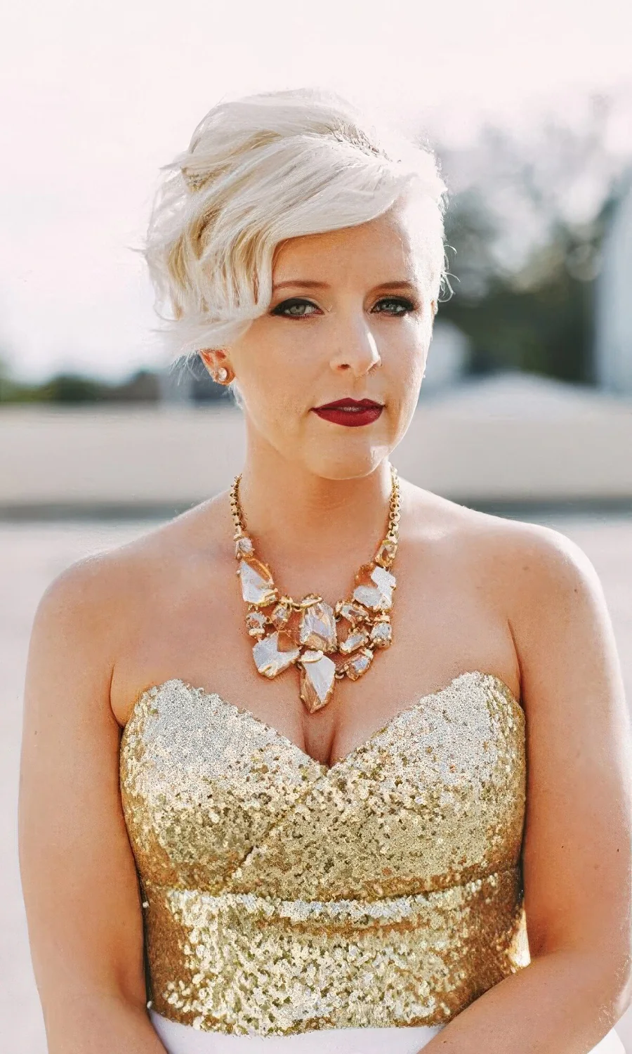 Long platinum blonde pixie cut with a lot of volume and wavy bangs.