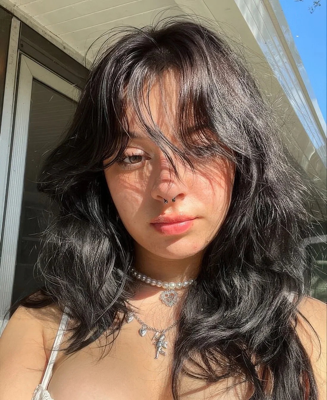Black medium wolf cut with wispy bangs and waves.