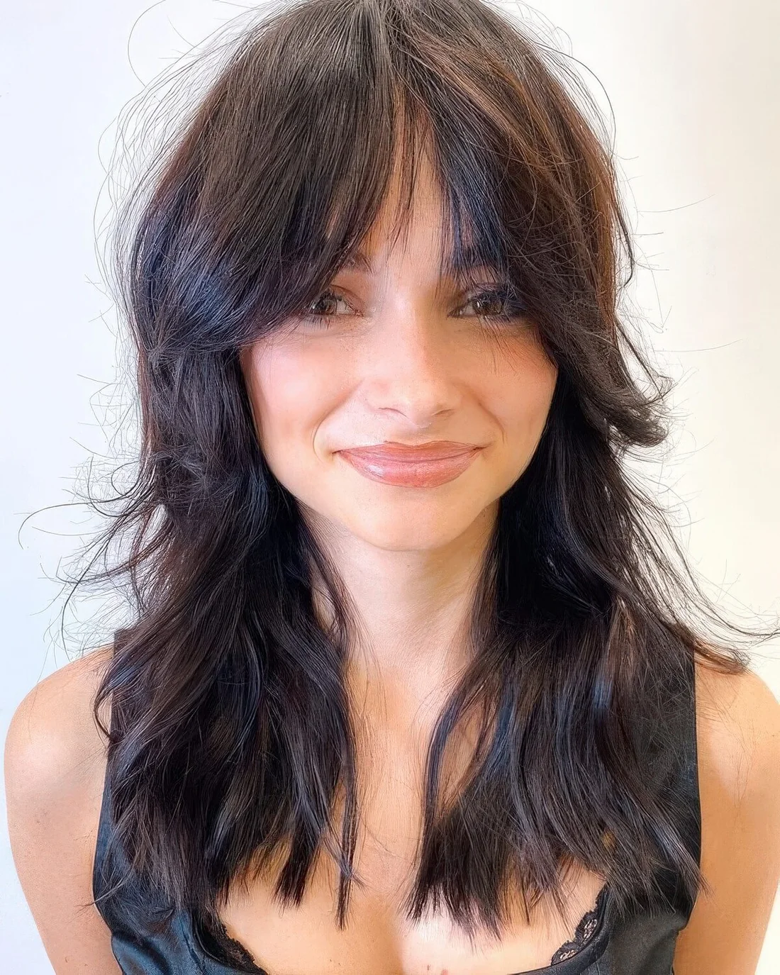 Dark brown long wolf cut with wispy bangs and waves down.