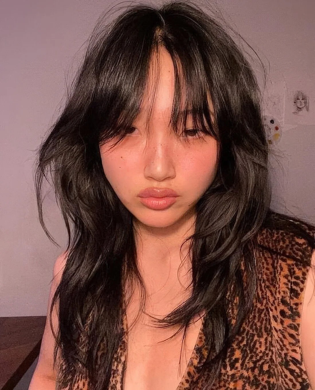 Long black wolf cut with wispy and bottleneck bangs and waves down went viral and that's not surprising.