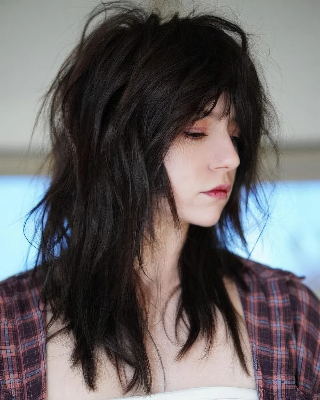 Black and super messy and textural wolf cut with a lot of volume.