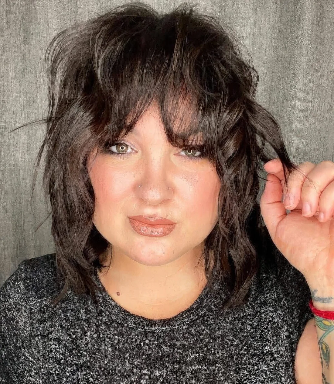 Brown thin wavy wolf cut with bottleneck bangs allows to create a volume and.
