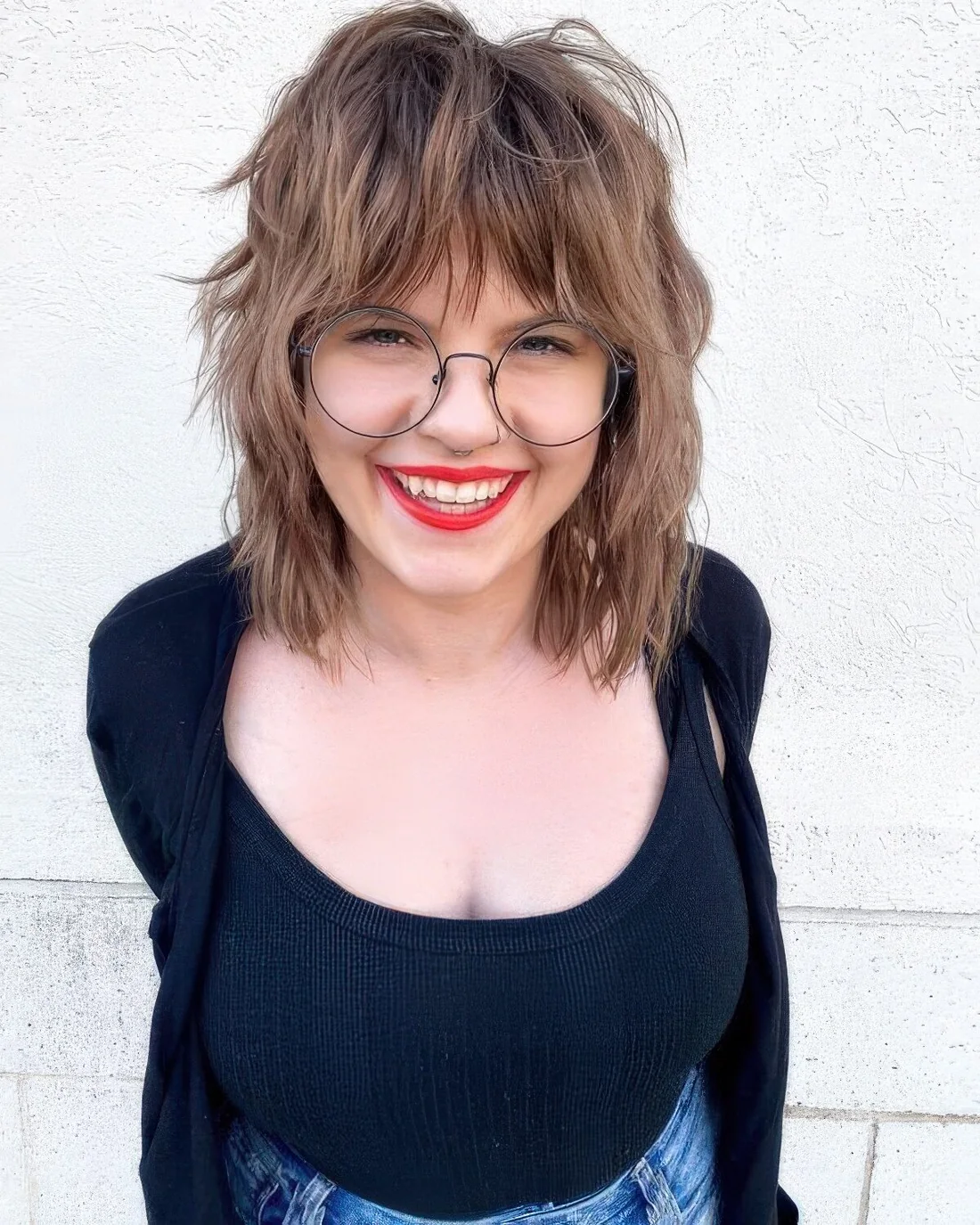 Light brown wolf cut with wispy layered bangs and textured hair.