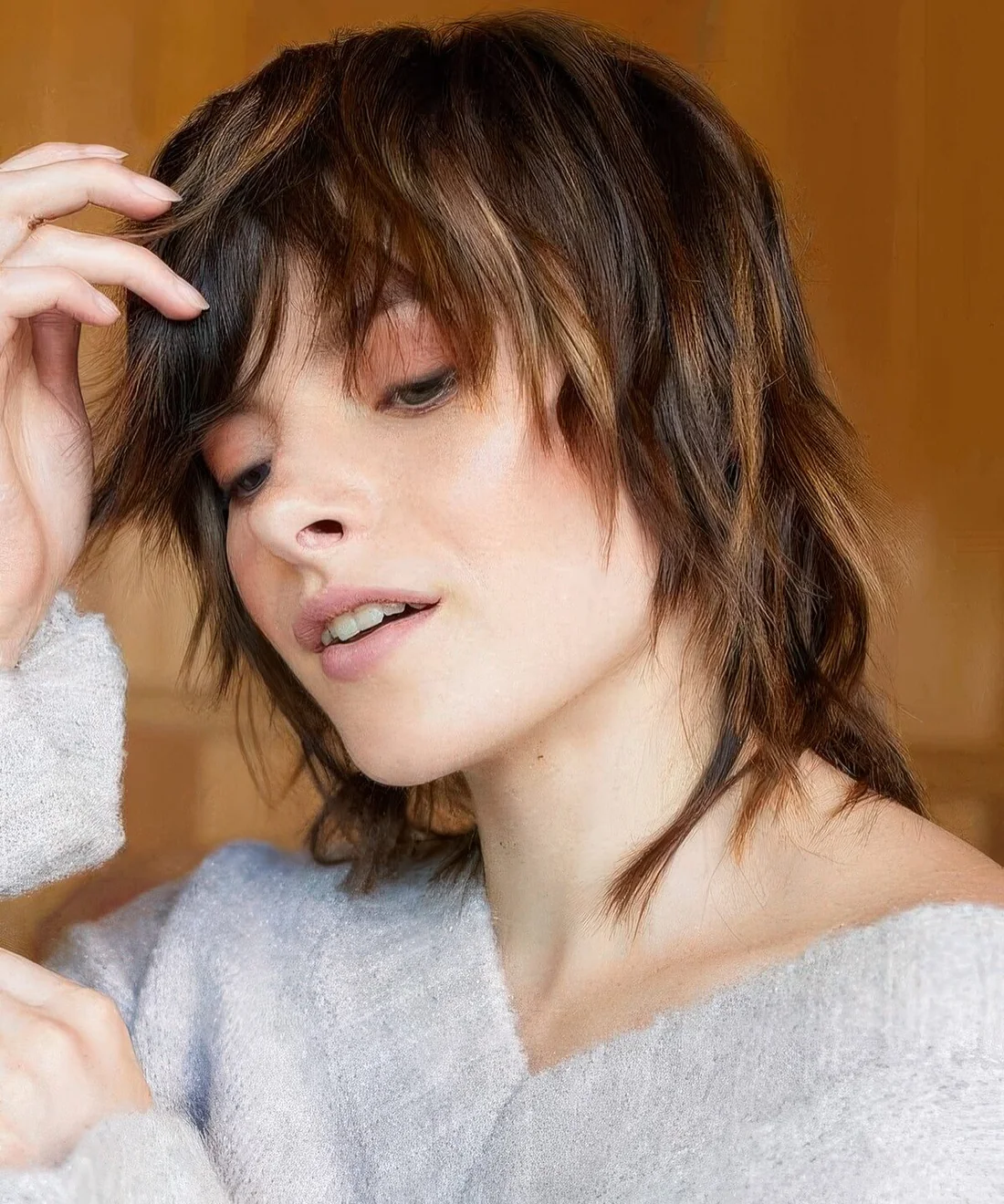Dark brown wolf haircut with caramel balayage, with layers and bangs.