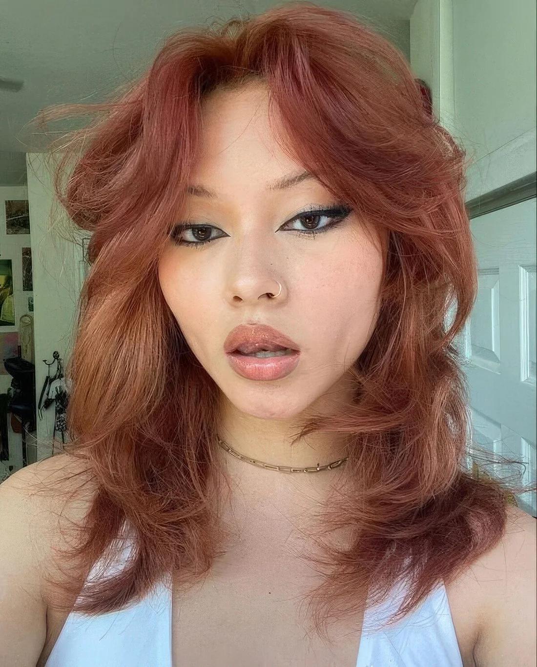 Ginger read medium-length wolf cut with center part.