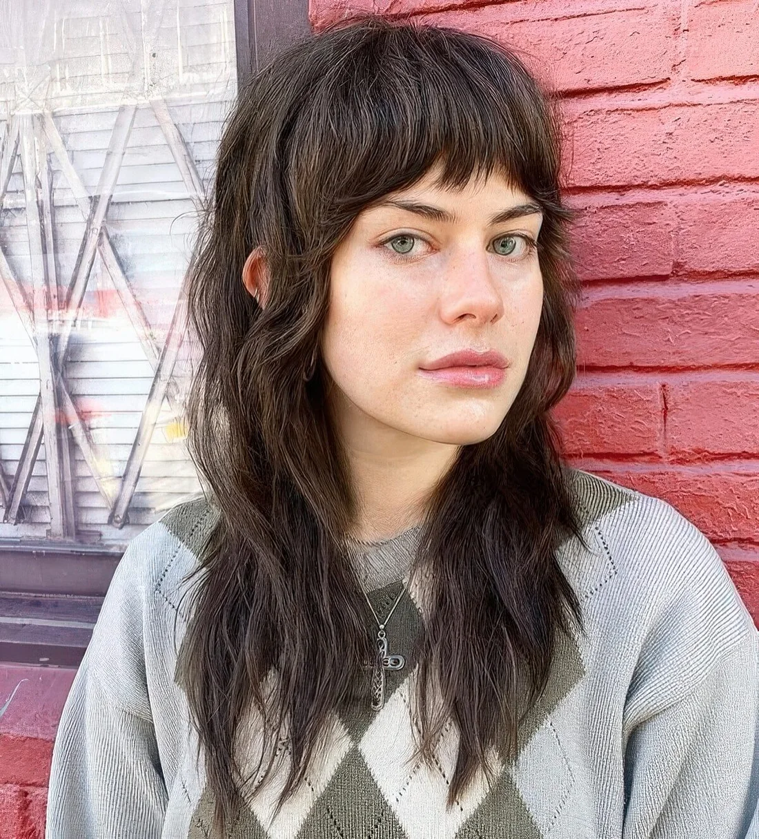 Long brown wolf cut with textured bangs, textured layers.