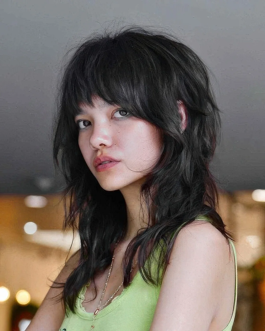 Shaggy wolf cut in black, with bangs and messy waves.