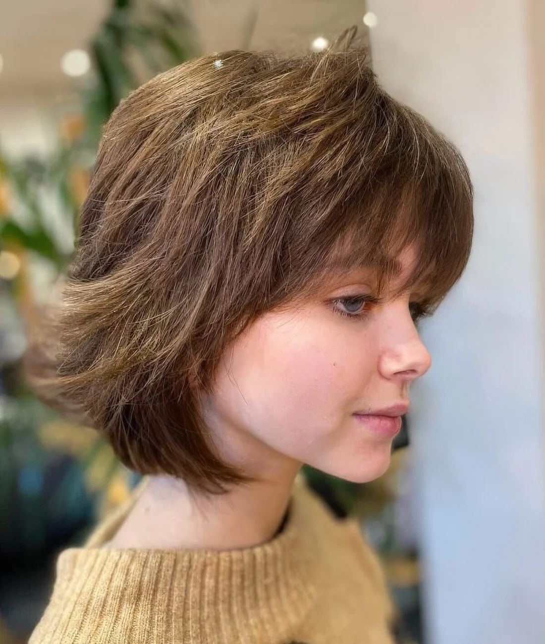 Textured medium-length brown wolf cut with bangs.