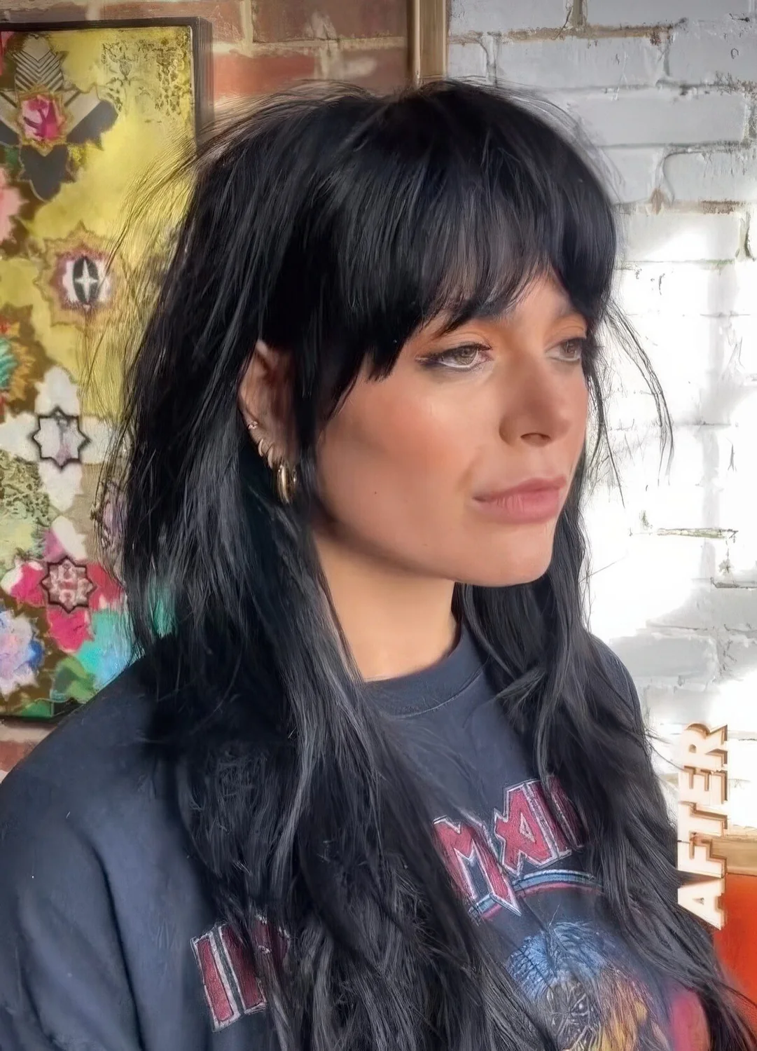 Black long wolf haircut with bottleneck bangs and waves down.