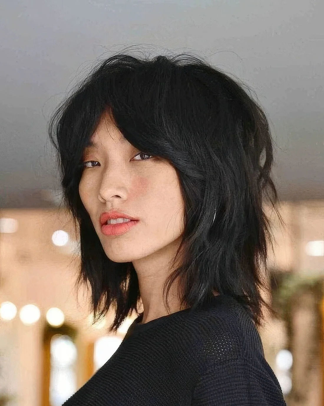 Black wolf cut with bottleneck bangs and layers, with center part.