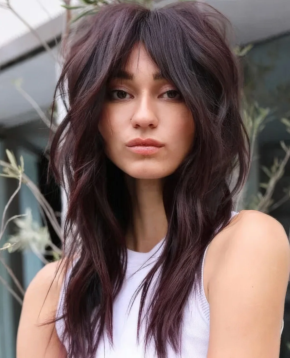Deep purple long wolf cut with volume only on top and waves plus bottleneck bangs.