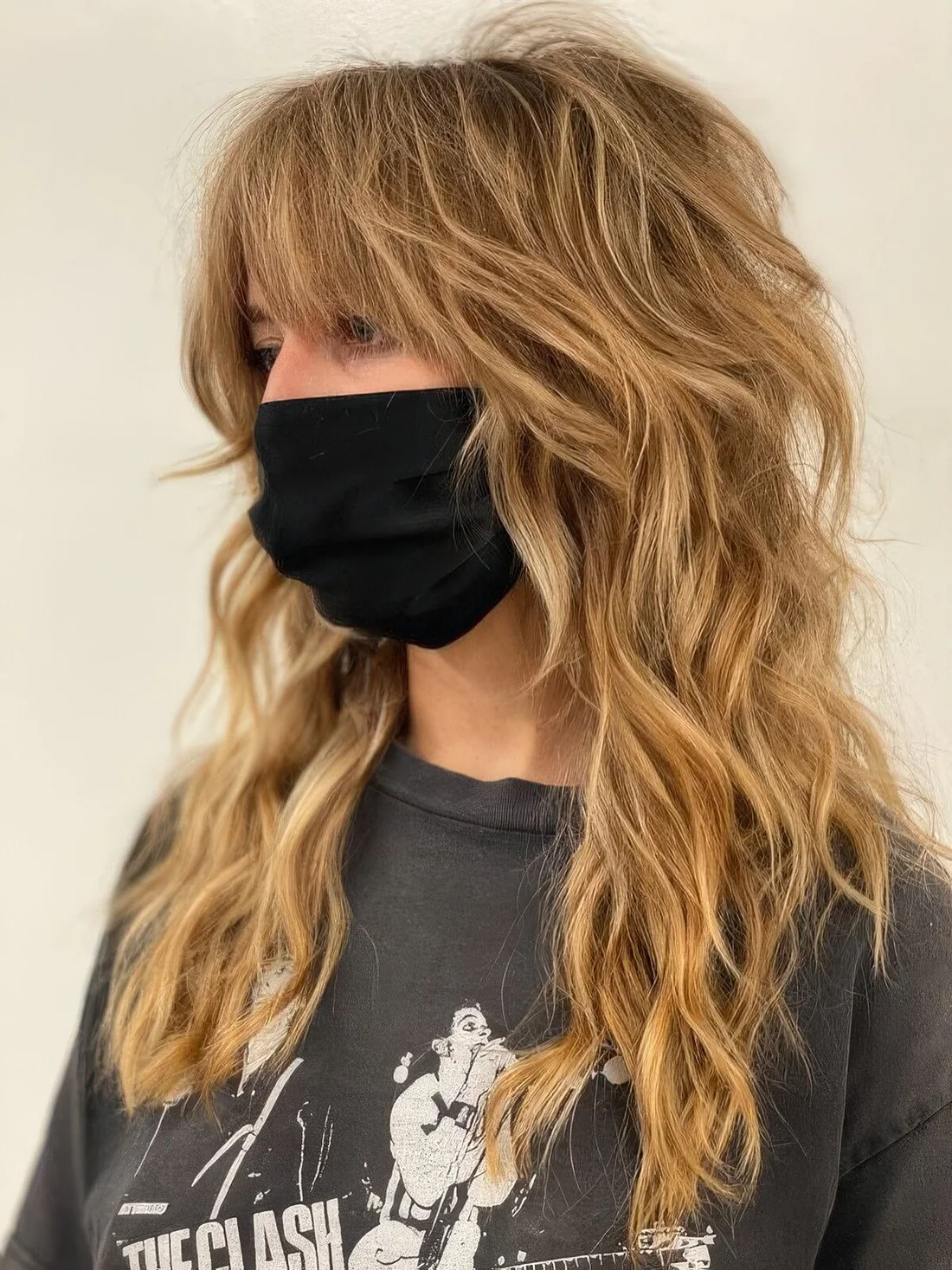 Honey blonde wolf cut with bottleneck bangs and waves down plus messy texture.
