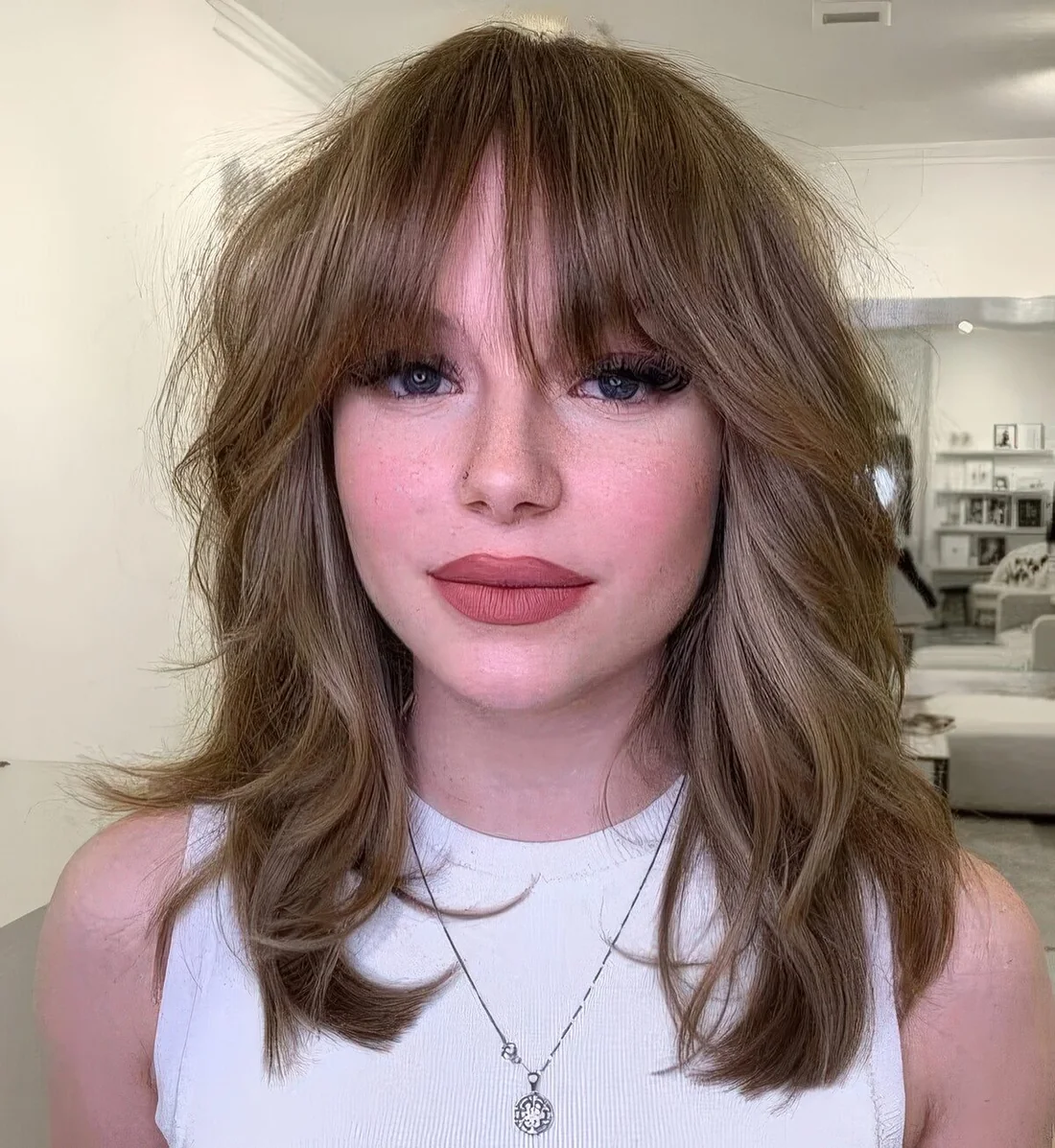 Light brunette medium wolf cut with bottleneck bangs and waves.