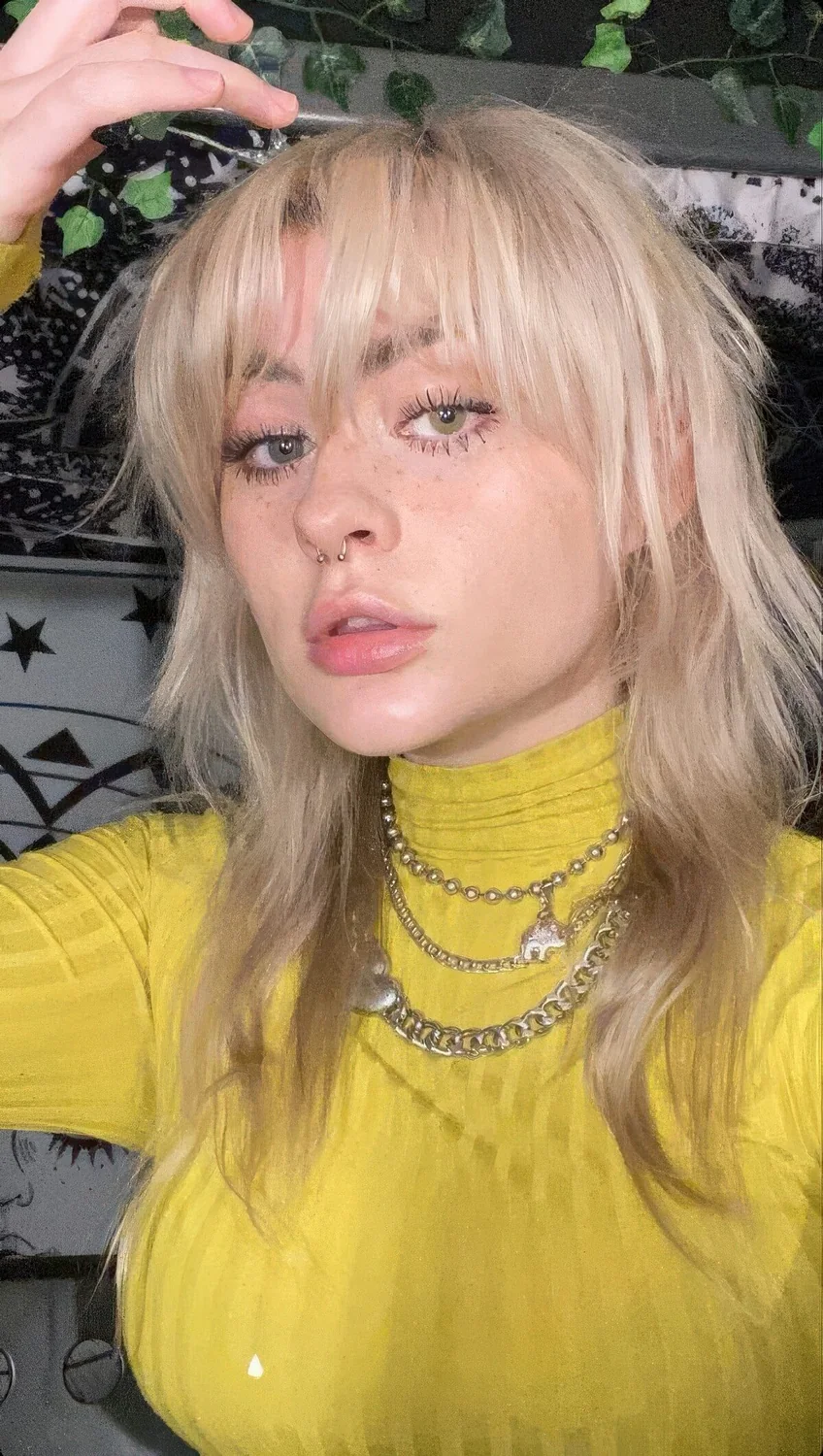 Platinum blonde medium wolf haircut with bottleneck bangs and waves.
