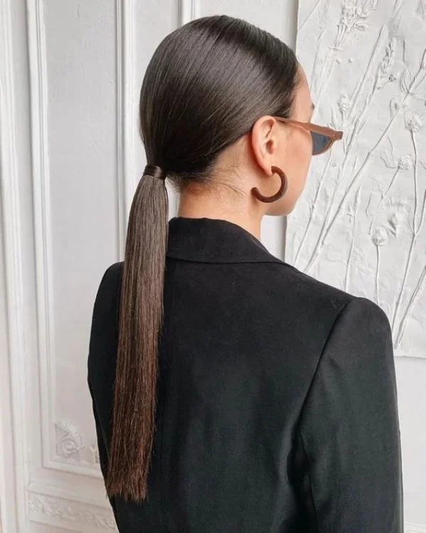 Photo showing sleek low pony, with the hairstyle clearly visible.