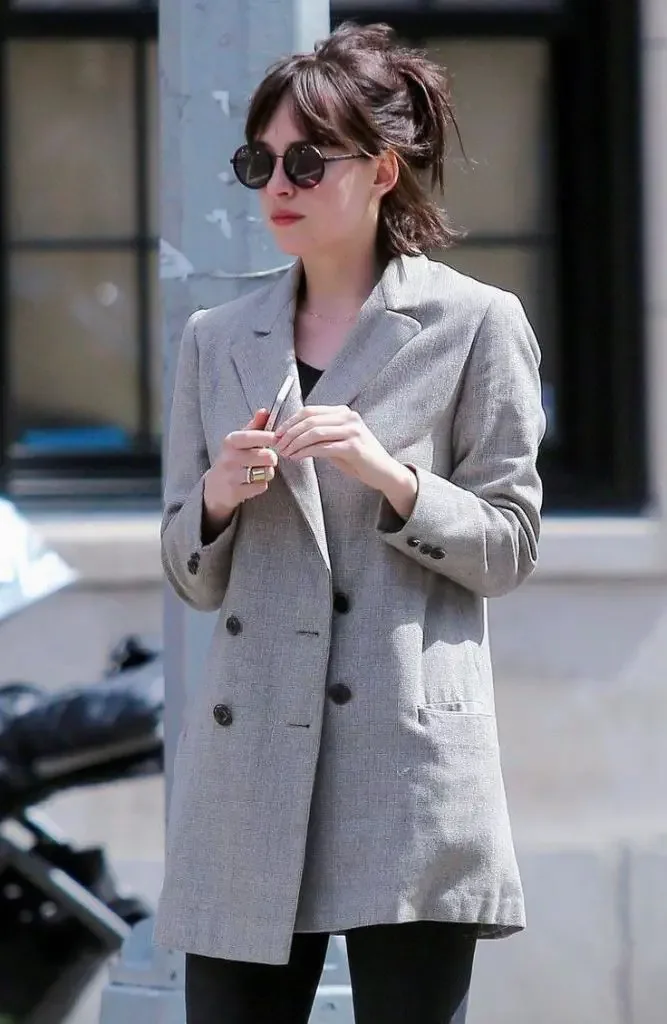 A brunette short cut is gathered into a loose mid-height ponytail with airy fringe and nape pieces
